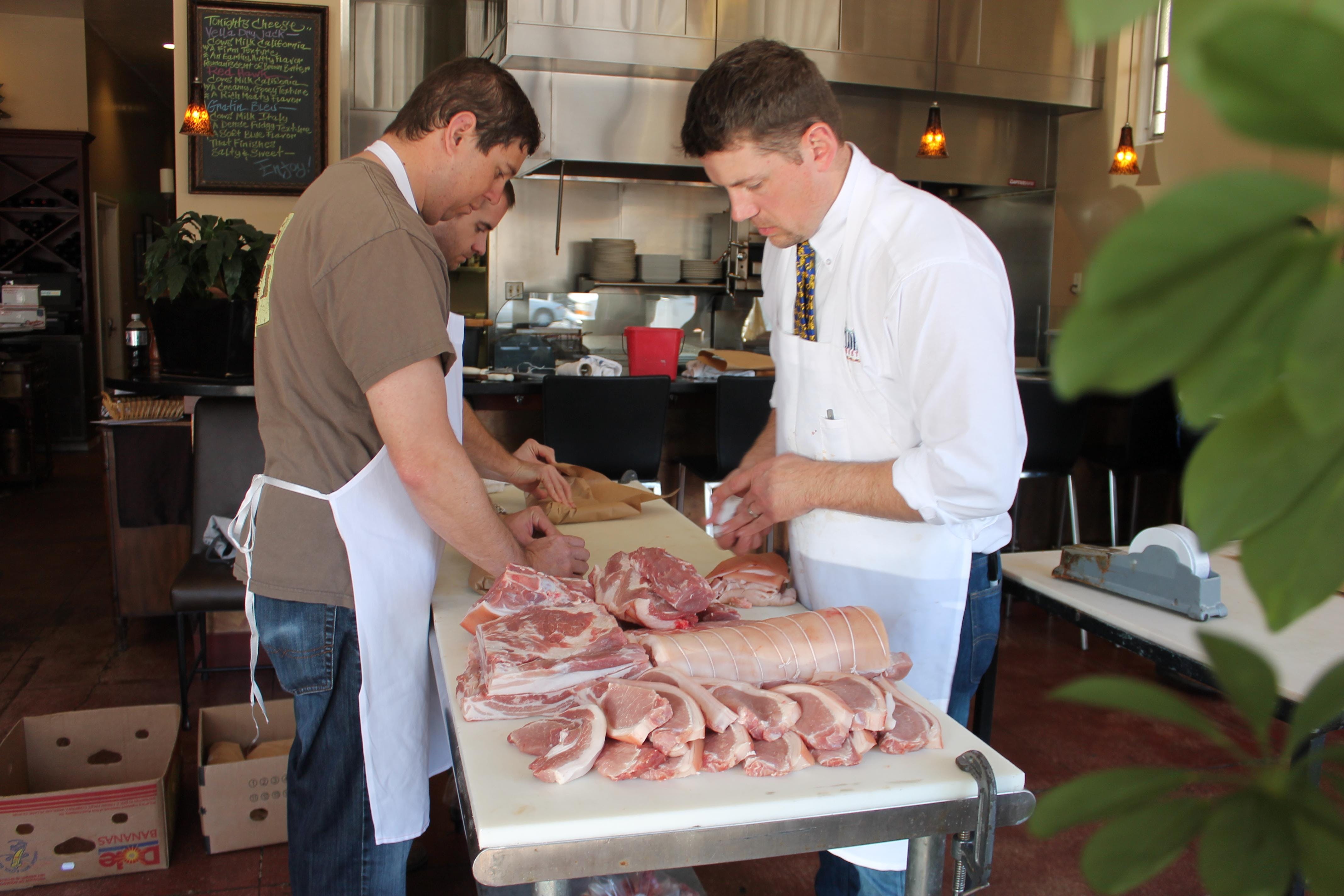 image of two men butchering pork